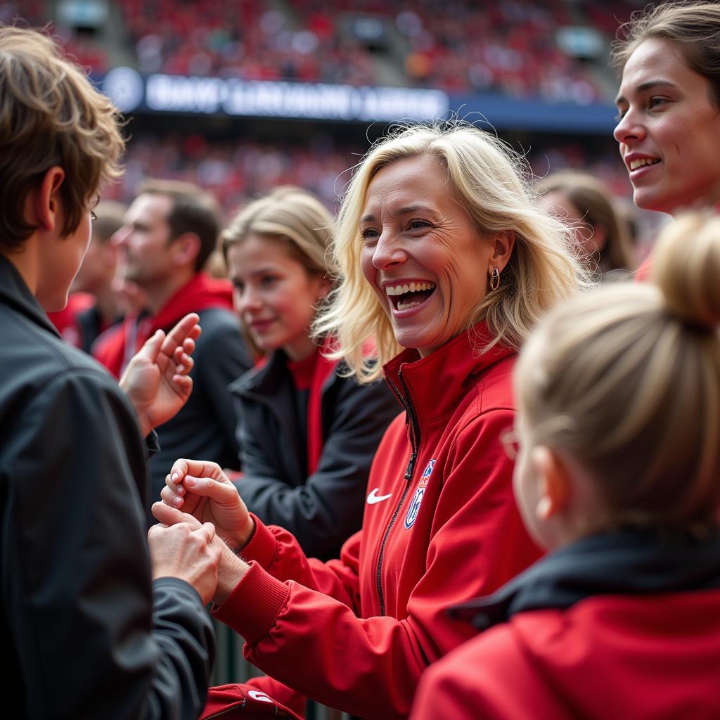 Barbara Fink im Austausch mit Fans und Spielern von Bayer Leverkusen