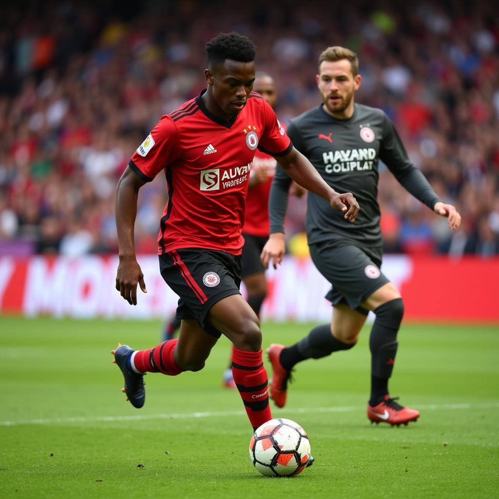 Leon Bailey im Bayer Leverkusen Trikot beim Dribbling gegen einen Gegenspieler