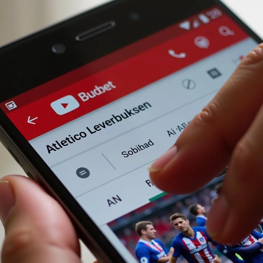 Smartphone zeigt YouTube Suche nach Atletico Leverkusen