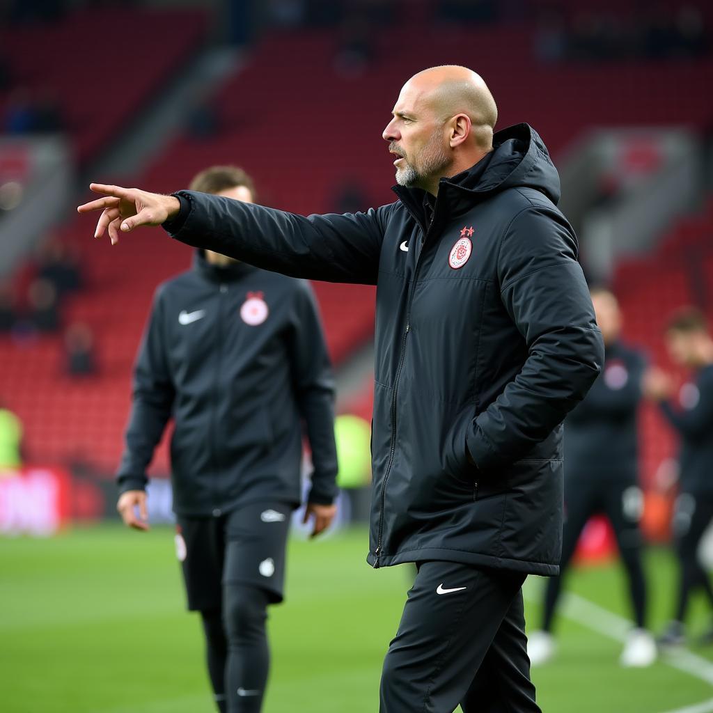 Adi Hütter, Trainer von Bayer 04 Leverkusen, gibt Anweisungen am Spielfeldrand.