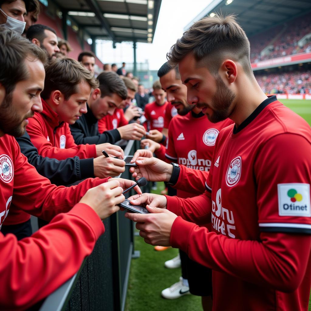 Bayer 04 Leverkusen Spieler interagieren mit Fans nach dem Spiel.