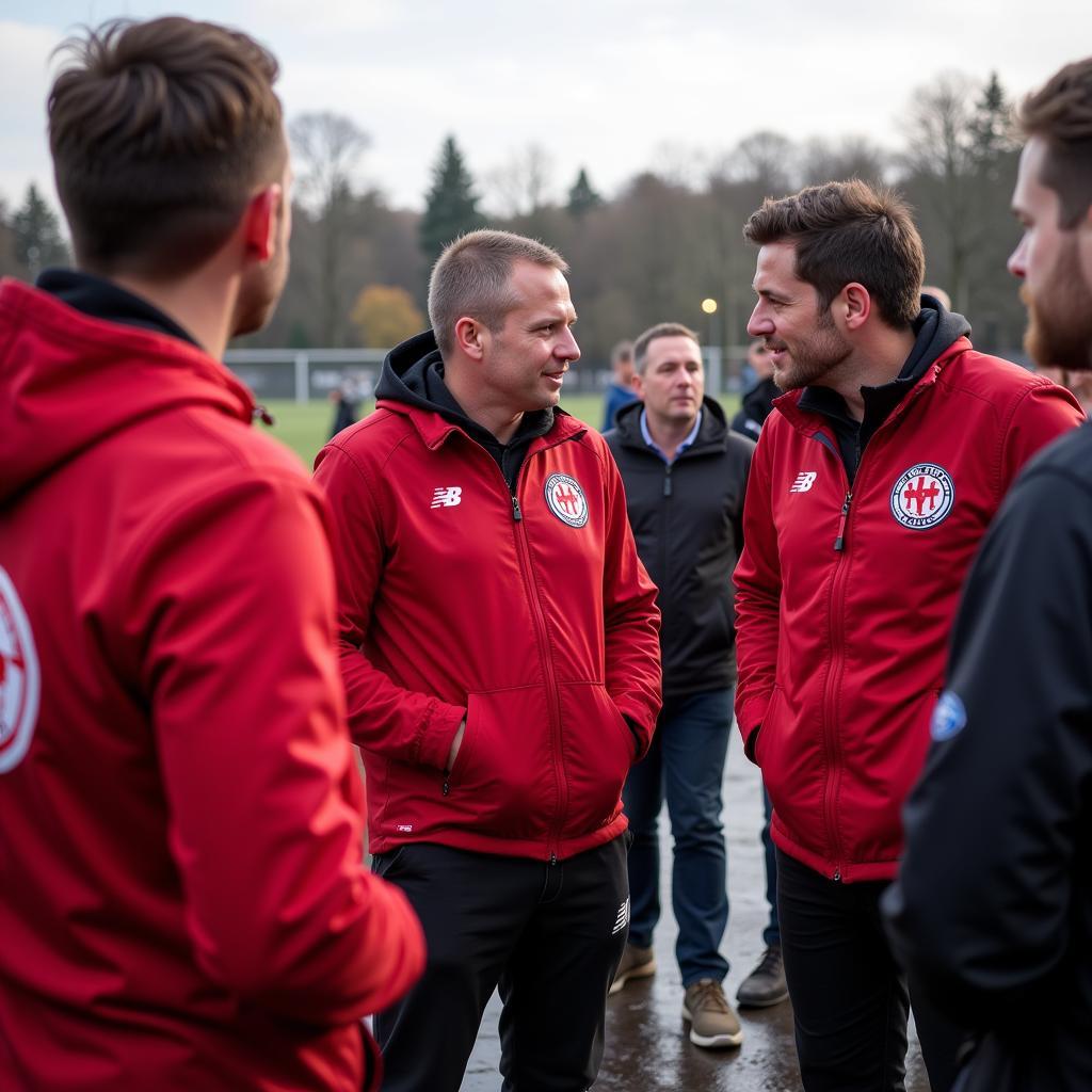 Fanbetreuer von Bayer 04 Leverkusen im Gespräch mit Fans in der Randstadt.