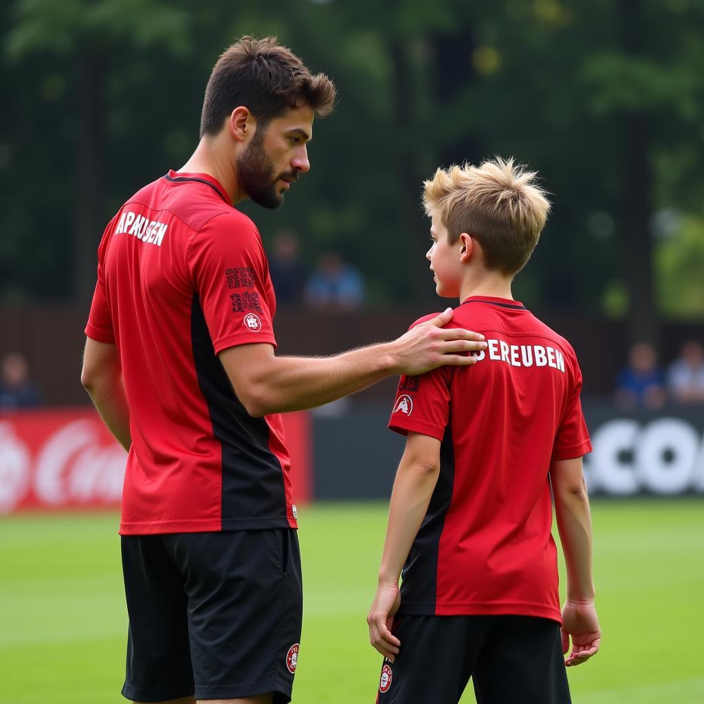 Xabi Alonso spricht mit einem jungen Spieler von Bayer 04 Leverkusen nach einem Trainingsspiel.