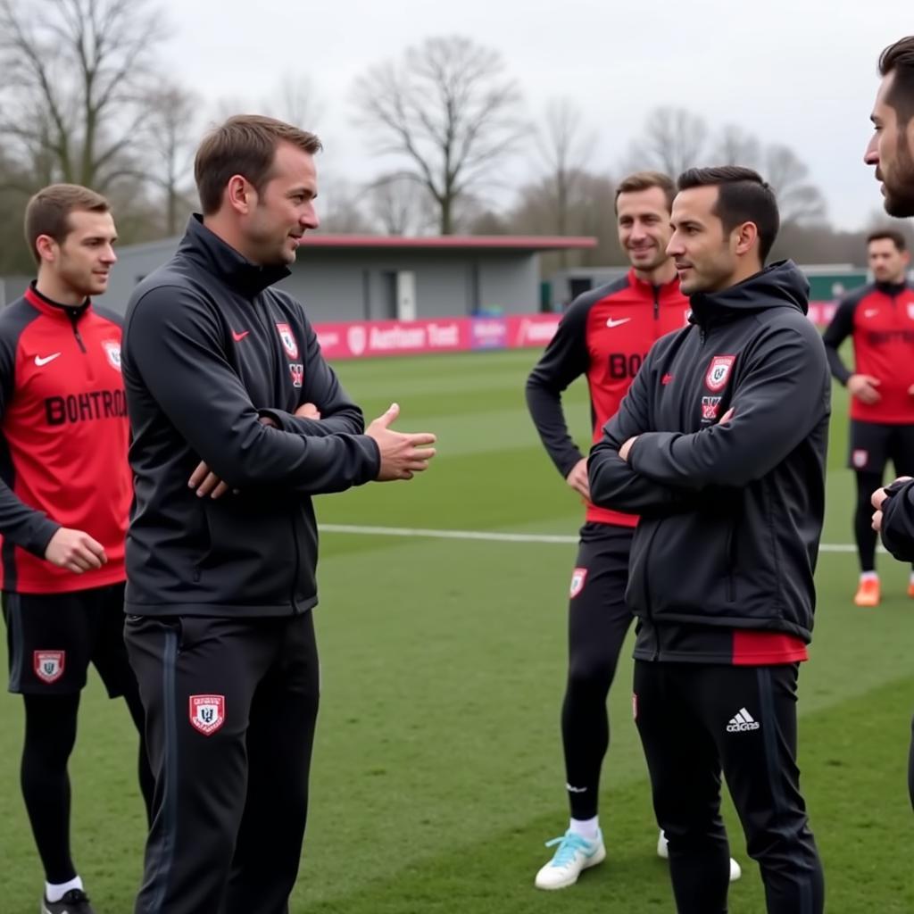 Frank Huettemann im Gespräch mit Spielern von Bayer Leverkusen